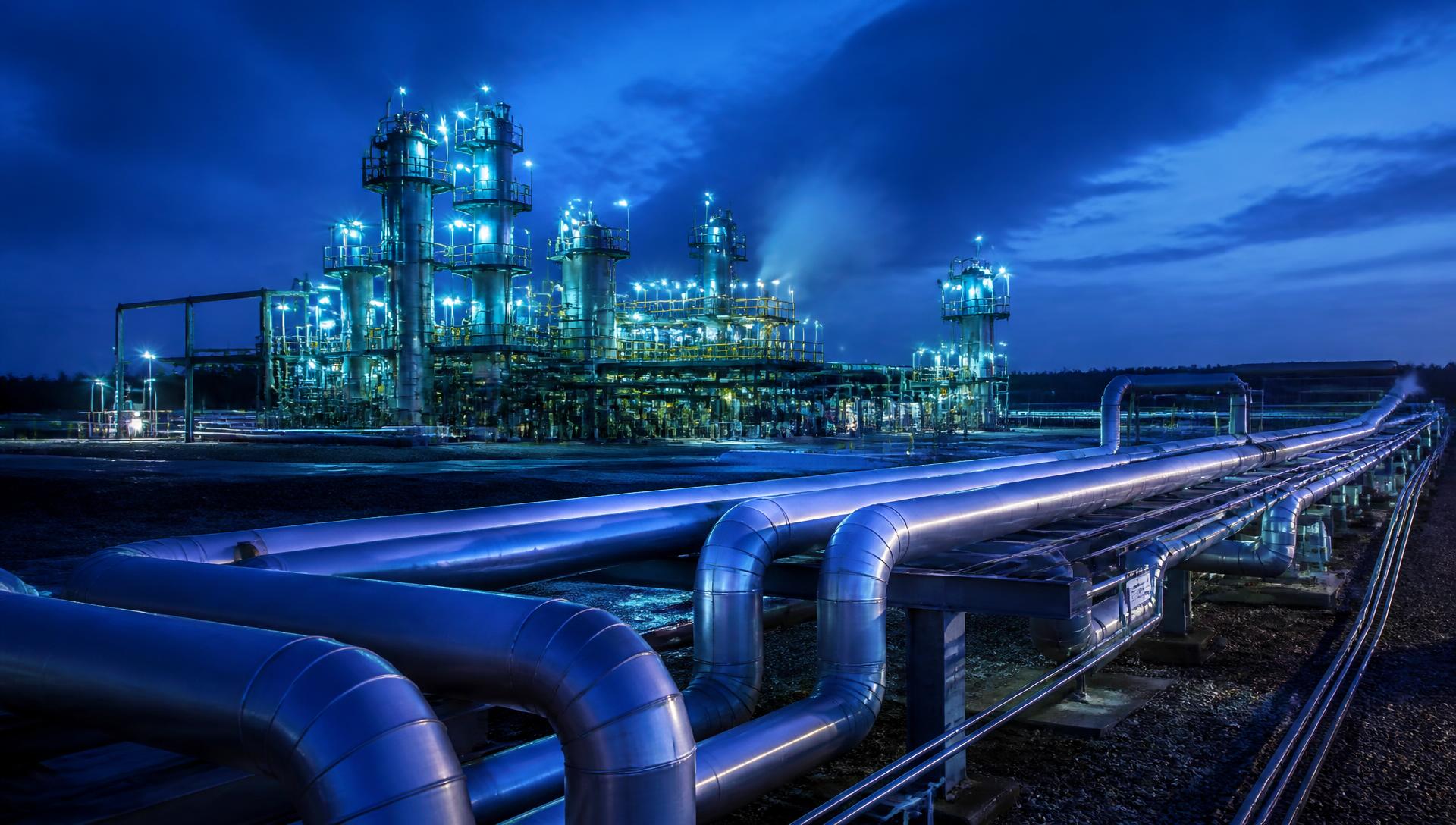 Gas processing plant and pipeline network illuminated at blue hour